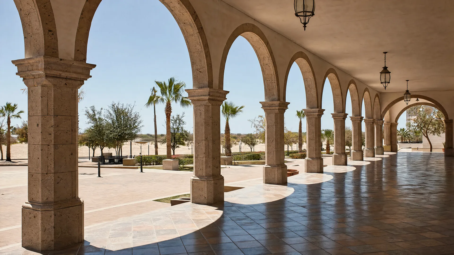 An empty stone colonnade with arched openings at midday